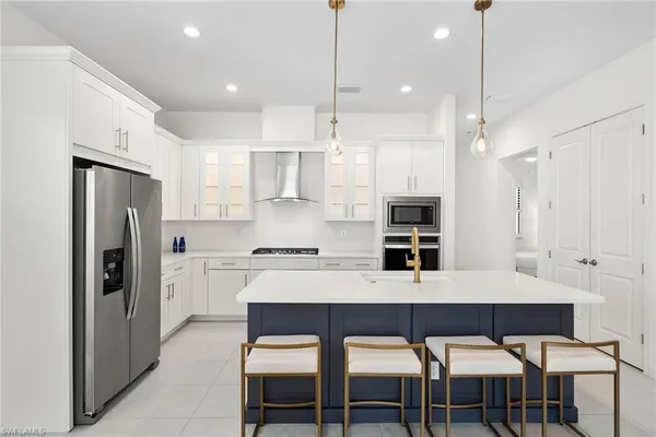 a kitchen with refrigerator a sink and chairs