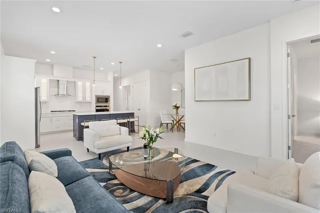 a living room with furniture and a view of kitchen