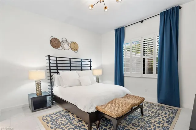 a bedroom with a bed and a window with a rug