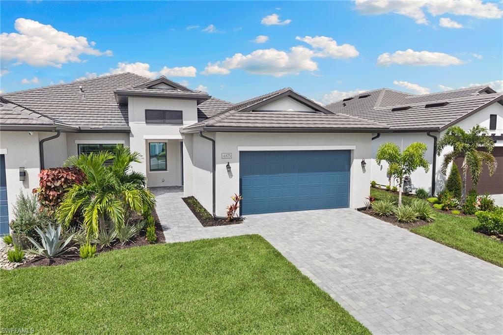 14875 Loggerhead Drive Naples, FL 34120 - Photo 24 of 28 a front view of a house with a yard and garage