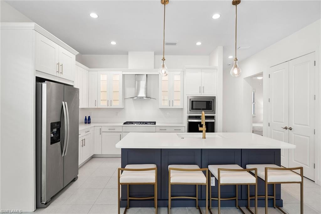 14875 Loggerhead Drive Naples, FL 34120 - Photo 3 of 28 a kitchen with refrigerator a sink and chairs