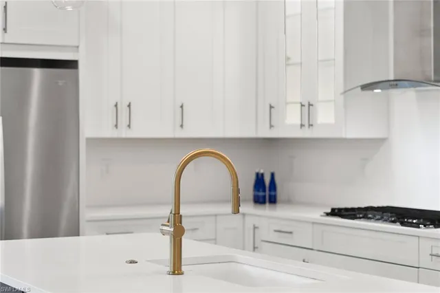 a close view of a sink a stove and cabinets
