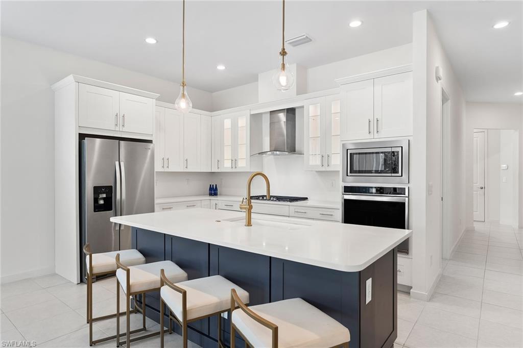 14875 Loggerhead Drive Naples, FL 34120 - Photo 6 of 28 a kitchen with a sink a refrigerator and white cabinets