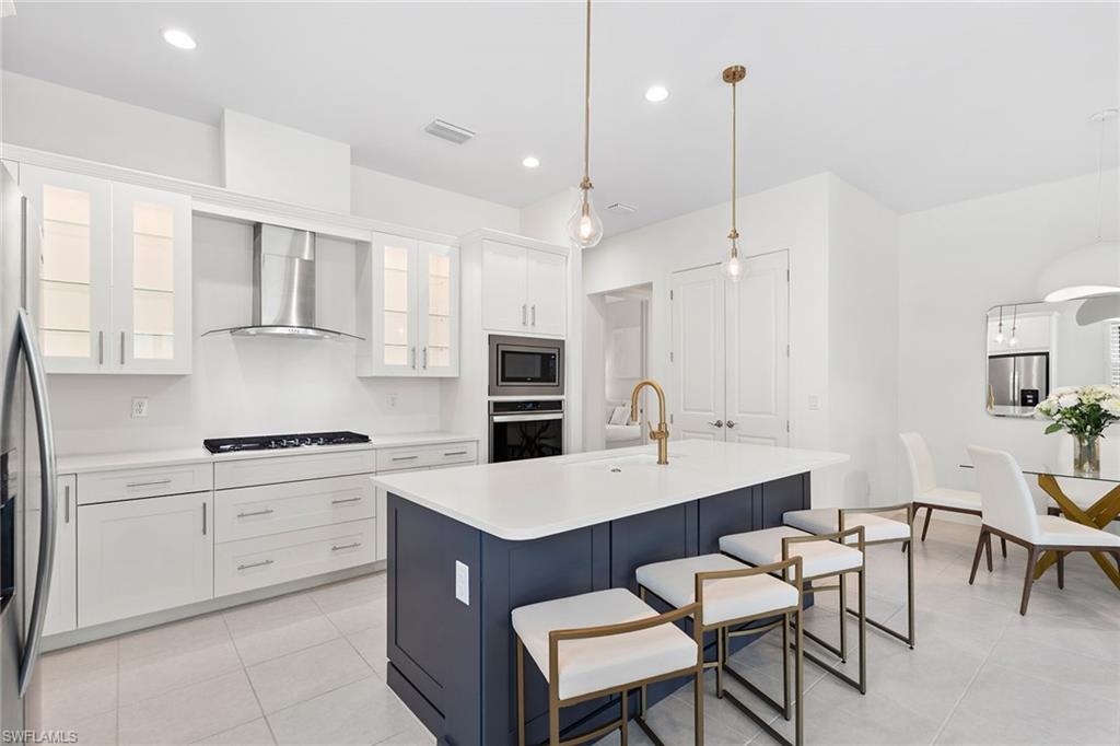 14875 Loggerhead Drive Naples, FL 34120 - Photo 7 of 28 a kitchen with a sink stove and refrigerator