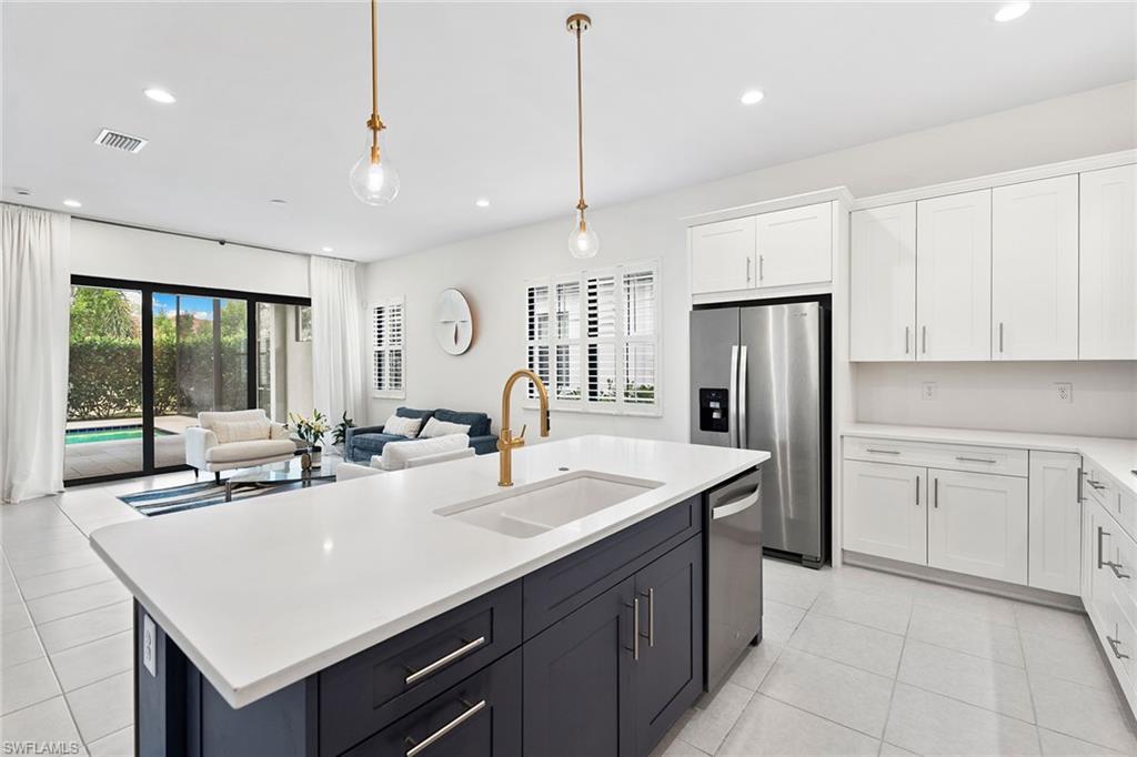 14875 Loggerhead Drive Naples, FL 34120 - Photo 9 of 28 a kitchen with stainless steel appliances granite countertop a sink a refrigerator and a white cabinets