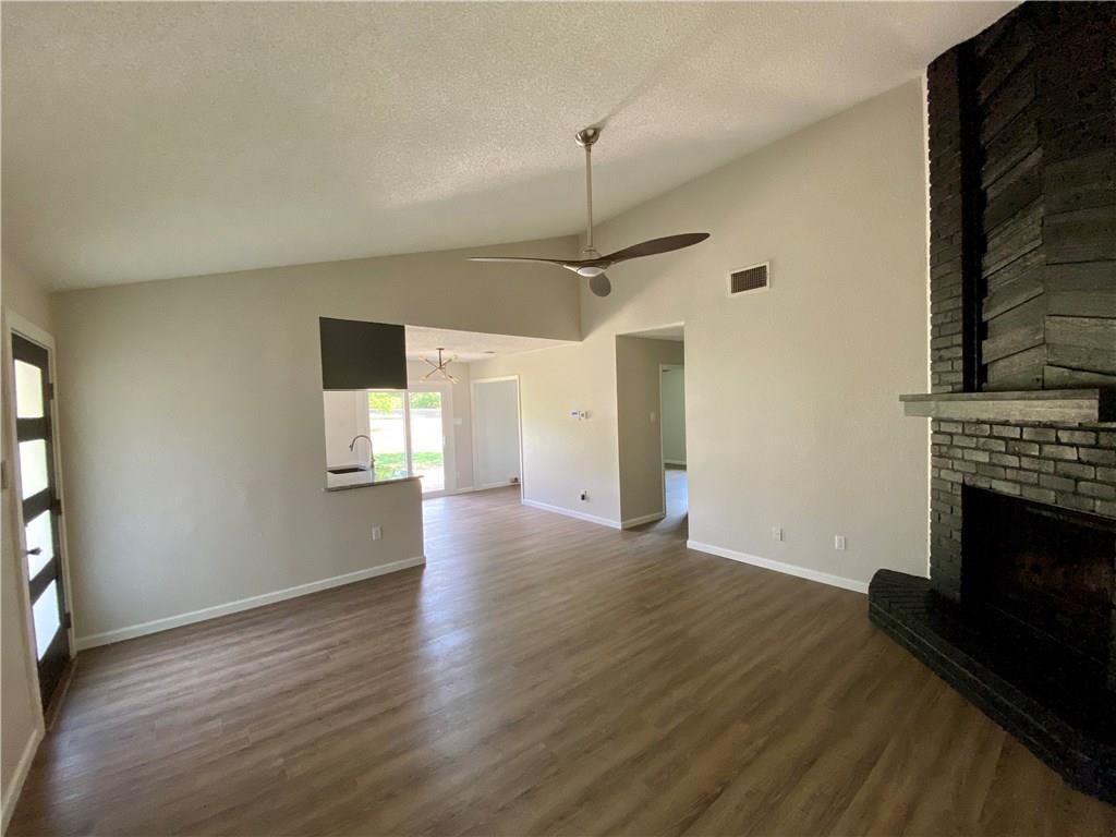 1715 Shadowview Drive, Unit B Austin, TX 78758 - Photo 11 of 28 A striking fireplace grounds this spacious living area with vaulted ceilings and durable wood flooring.