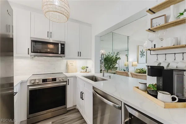 a kitchen with stainless steel appliances a stove microwave and sink