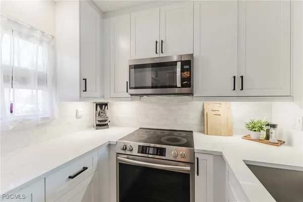 a kitchen with cabinets stainless steel appliances and a sink