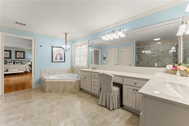 a large en suite bathroom with a granite countertop tub sink and mirror