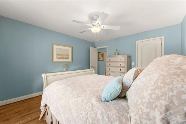 a spacious bedroom with a bed and wooden floor