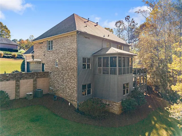 a view of a yard with plants and large trees