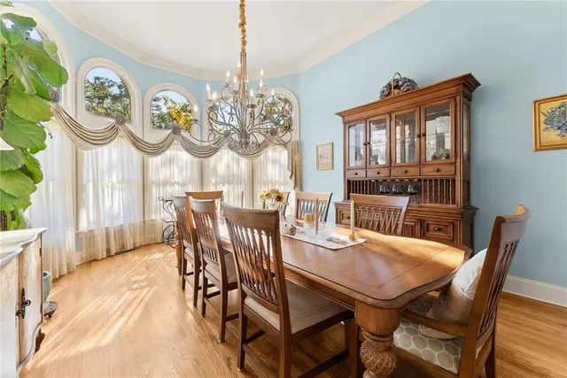 a view of a dining room with furniture a chandelier and wooden floor