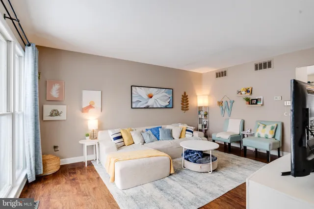 a living room with furniture and a wooden floor