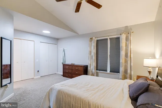 a bedroom with a bed and a lamp on dresser