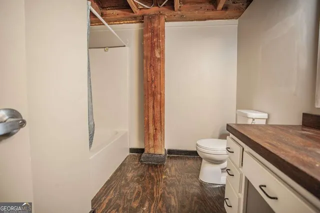a bathroom with a granite countertop toilet and a sink