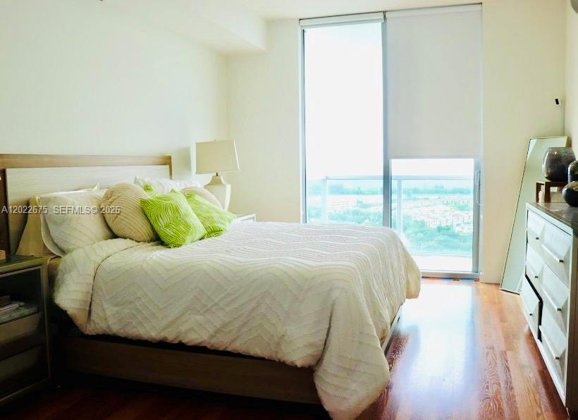 2681 North Flamingo Road, Unit 2602S Sunrise, FL 33323 - Photo 6 of 18 a bedroom with a bed and wooden floor