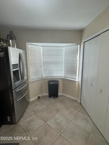 a kitchen with white cabinets and refrigerator