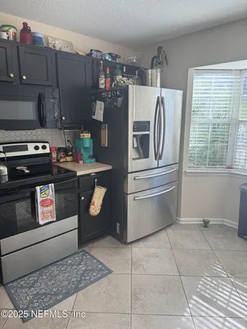 a kitchen with stainless steel appliances granite countertop a stove a refrigerator and a cabinets