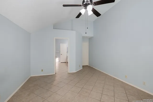 an empty room with a ceiling fan and carpet