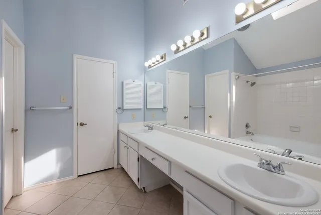 a spacious bathroom with a double vanity sink mirror and double