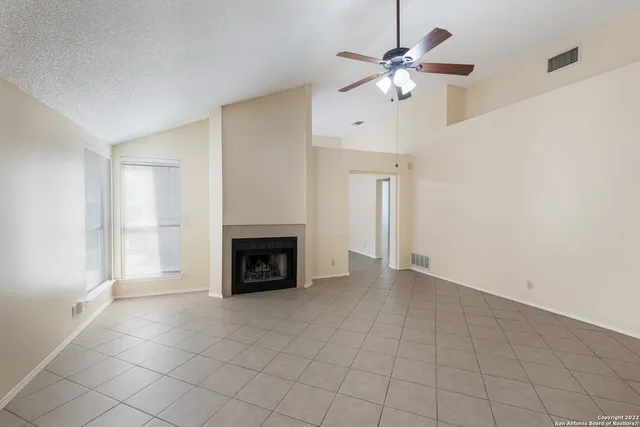 an empty room with fireplace and fan