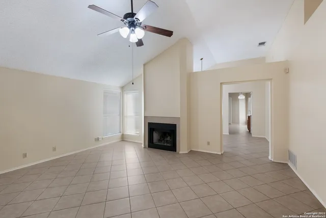 a view of a livingroom with a fireplace and a chandelier fan