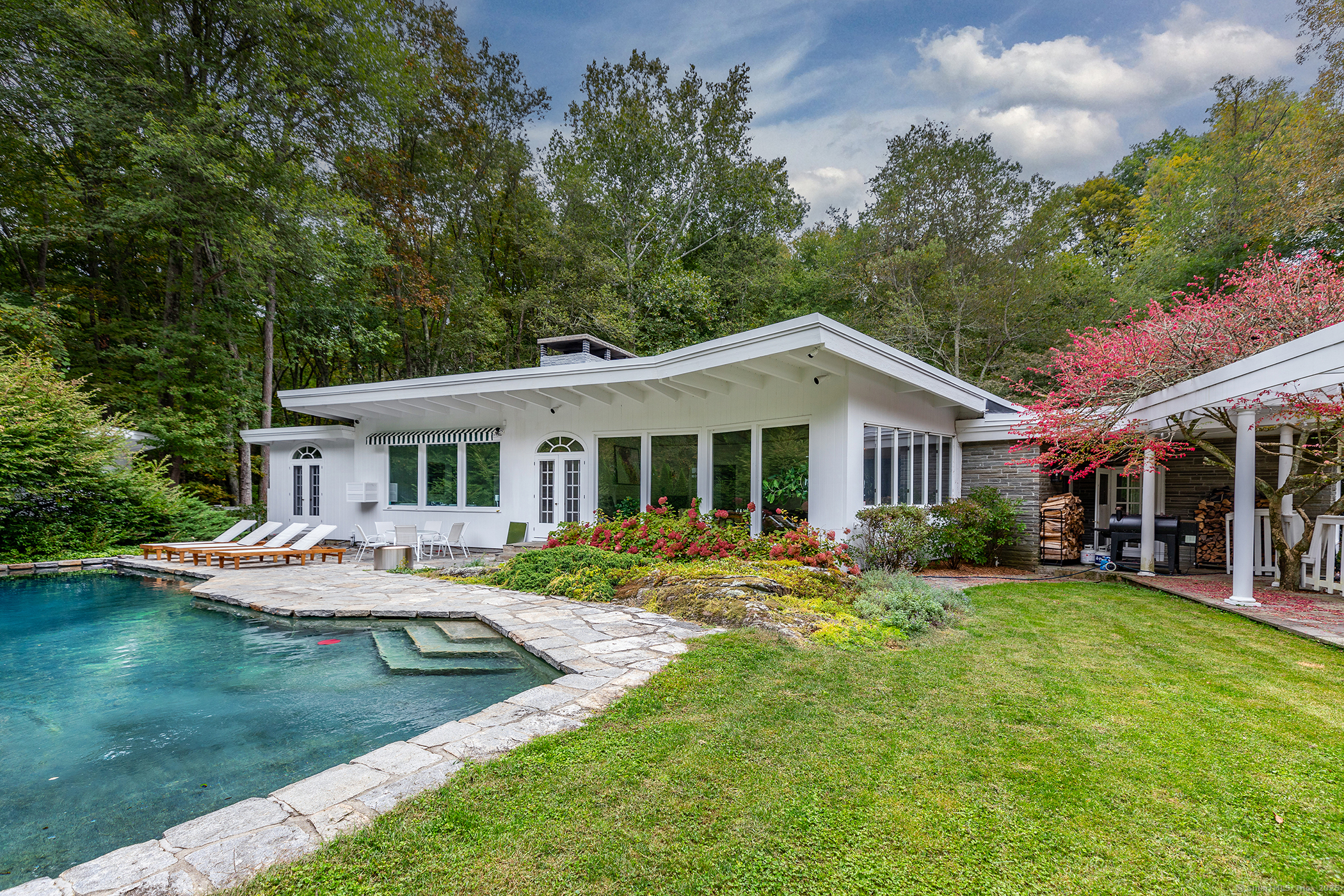 a view of a house with a big yard and large trees