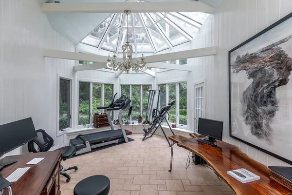 a living room with patio furniture and a chandelier