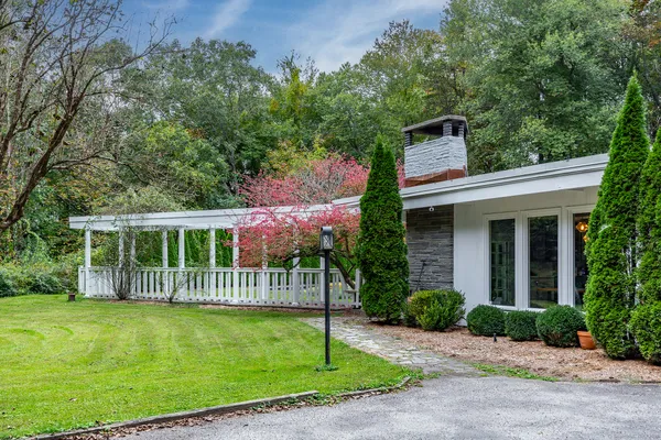 a front view of a house with a garden and plants