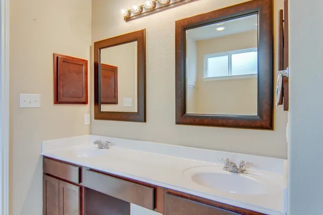 a bathroom with 2 sink and a mirror