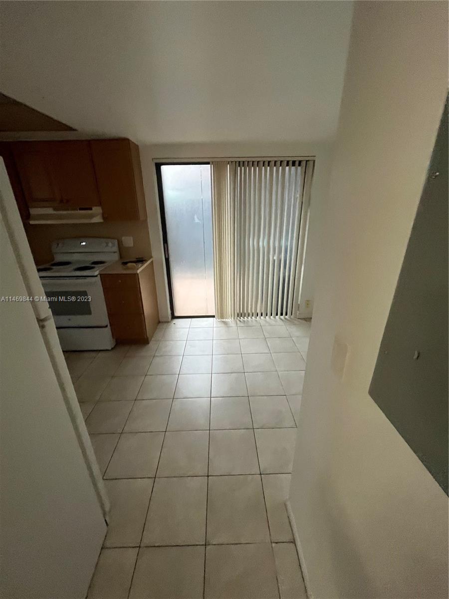 The Crossings Miami, FL 33186 - Photo 12 of 14 a view of an empty room with kitchen and wooden floor