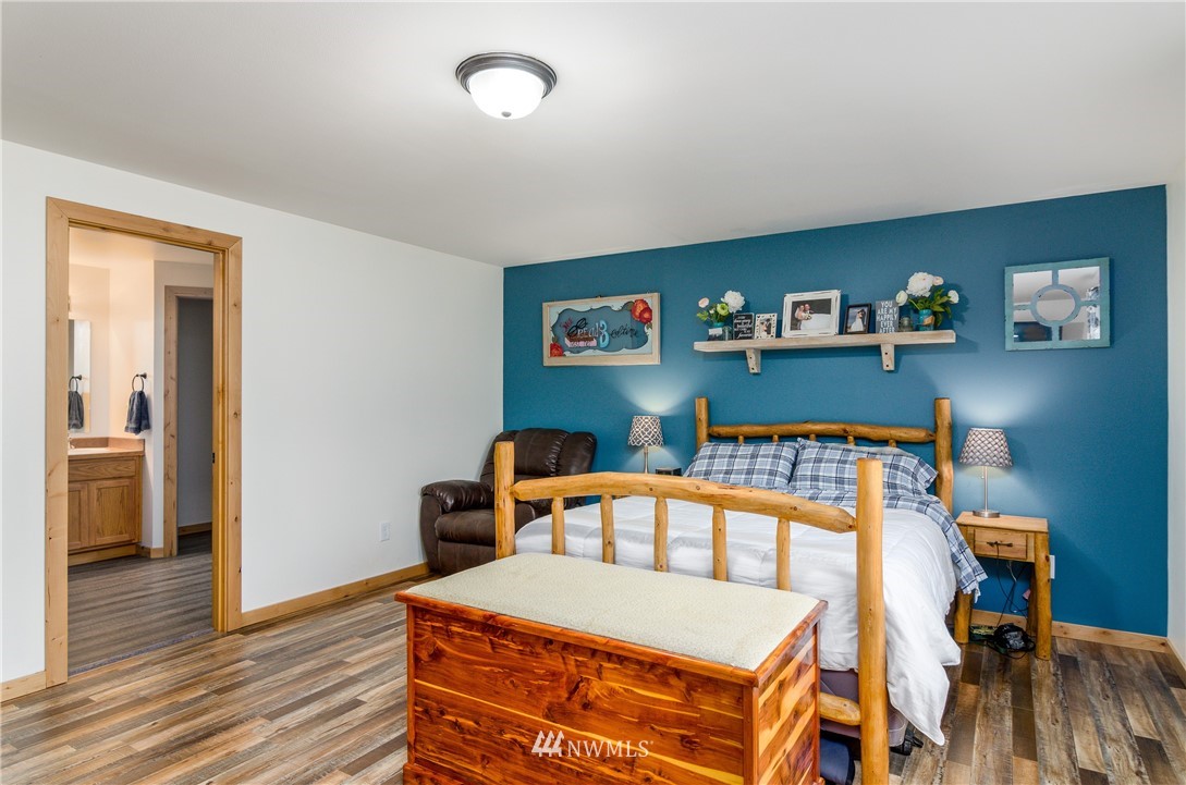 243 Gartner Road Winlock, WA 98596 - Photo 14 of 38 a bedroom with a bed and wooden floor