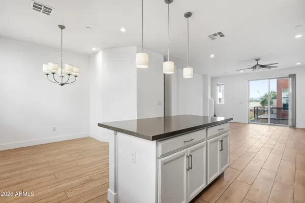 a kitchen with a sink chandelier and wooden floor