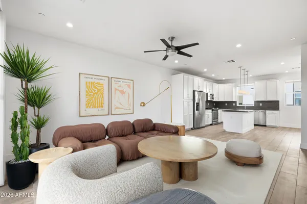 a living room with furniture kitchen view and a potted plant