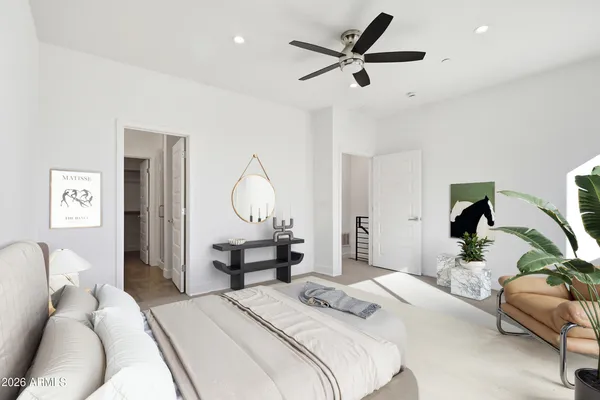 a bedroom with a bed a chandelier and a mirror on the dresser