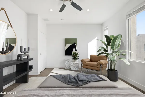a living room with furniture hard wood floor and a potted plant