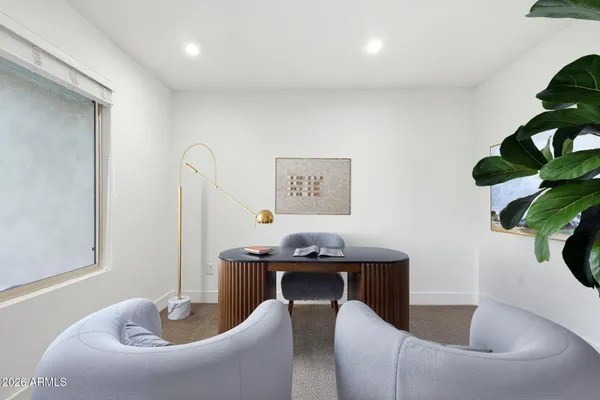 a dining room with furniture and a potted plant