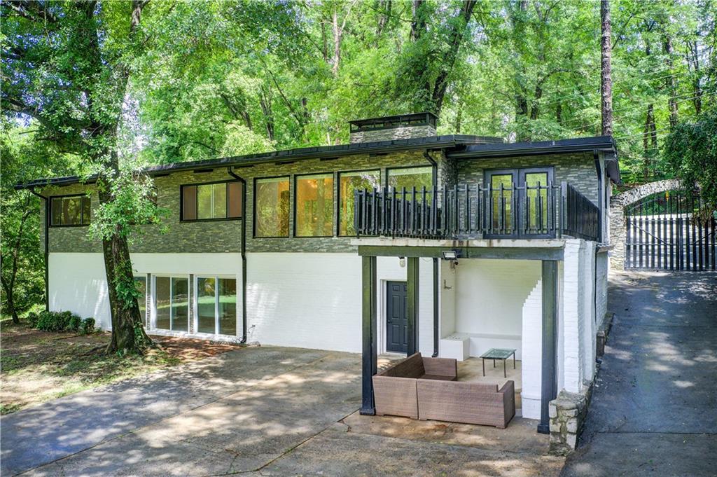 1676 Moores Mill Road Northwest Atlanta, GA 30327 - Photo 30 of 32 a front view of a house with a porch