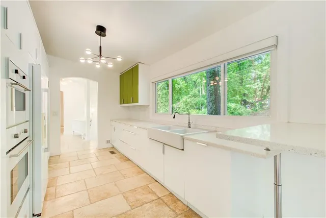 a large white kitchen with a large window
