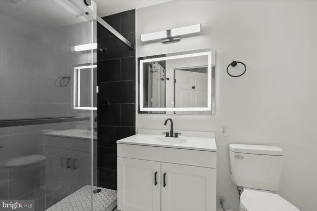 a bathroom with a sink a toilet and shower