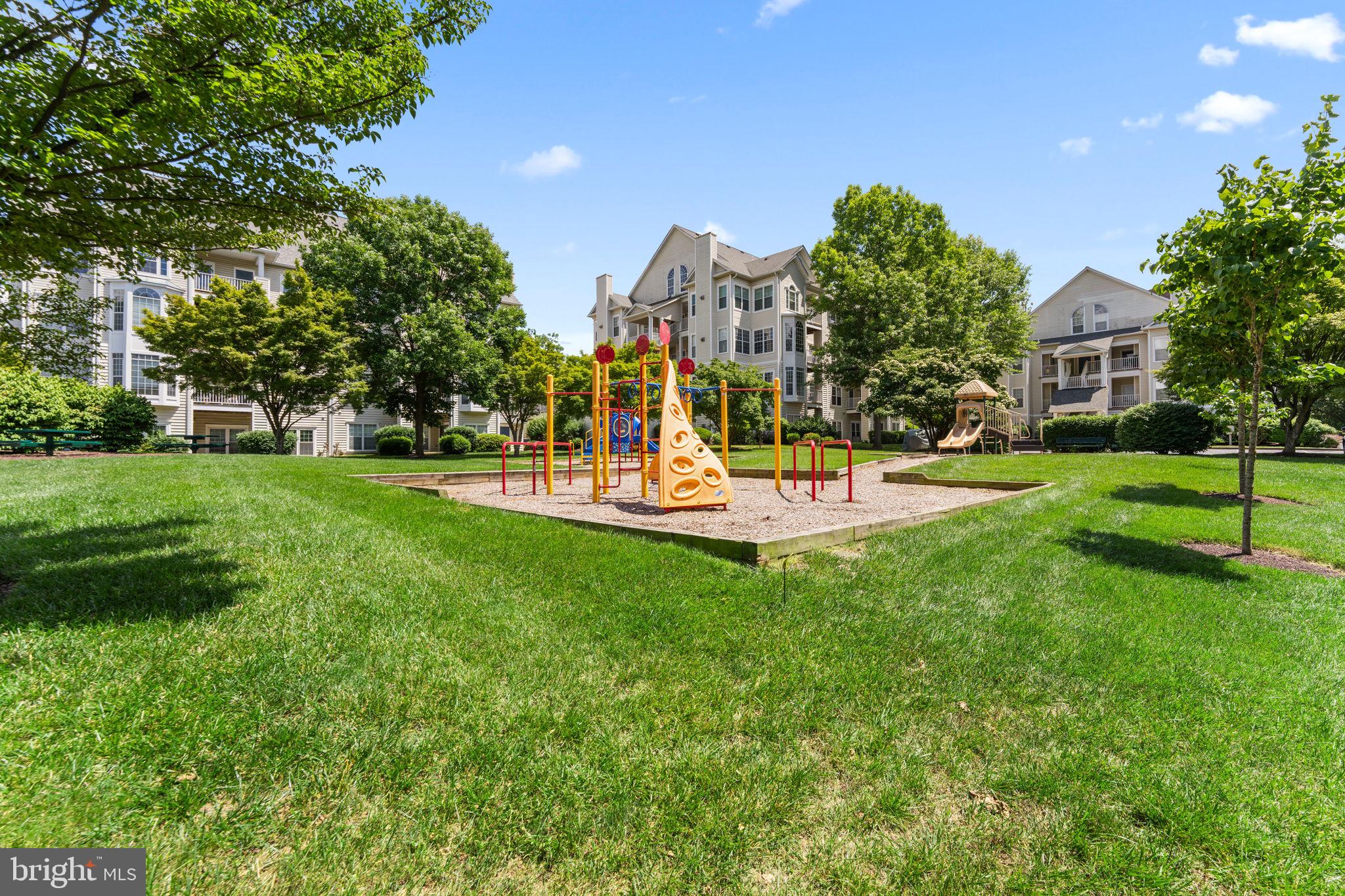 18521 Boysenberry Drive, Unit 242172 Gaithersburg, MD 20879 - Photo 32 of 43 a view of a park with swings and slides