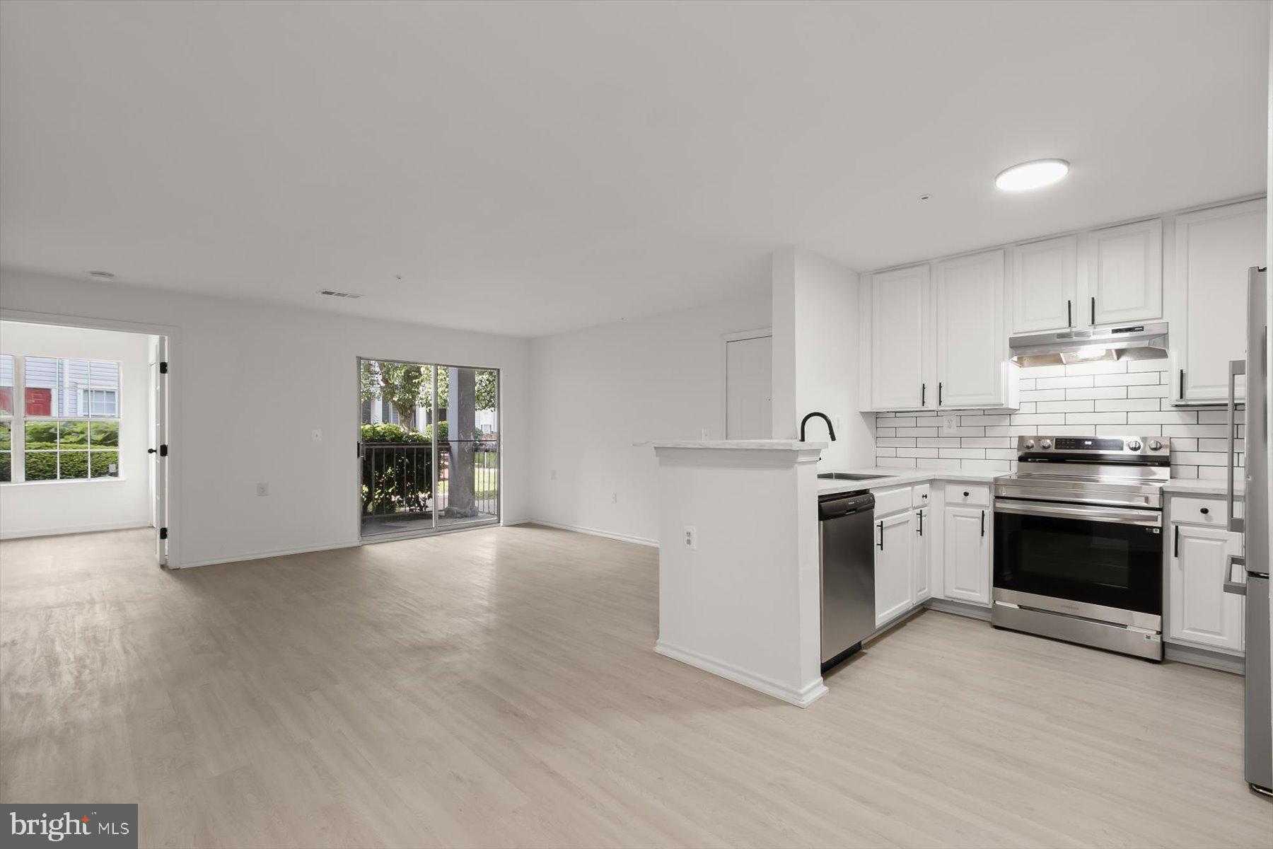 18521 Boysenberry Drive, Unit 242172 Gaithersburg, MD 20879 - Photo 9 of 43 a kitchen with granite countertop a stove top oven sink and cabinets