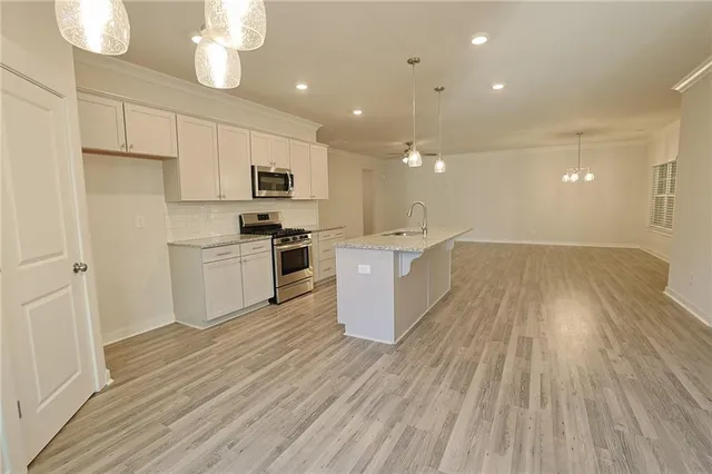 a kitchen with granite countertop a stove and a microwave