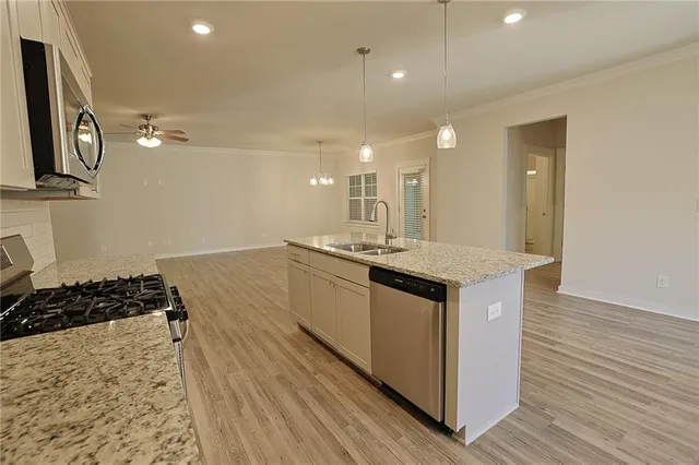 a kitchen with kitchen island sink stove and cabinets