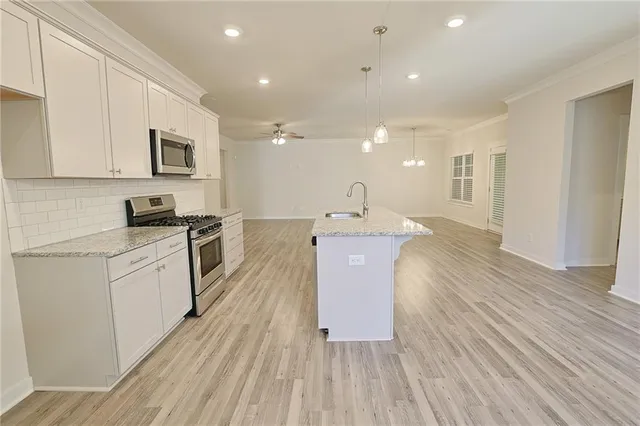 a kitchen with a white wooden floors a stove and a refrigerator