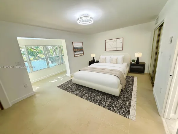 a bedroom with a bed and a large window
