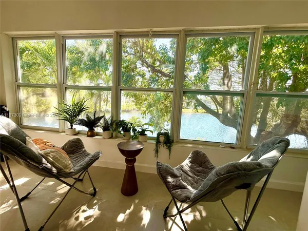 a living room with furniture and floor to ceiling windows