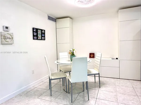a dining room with furniture and a potted plant