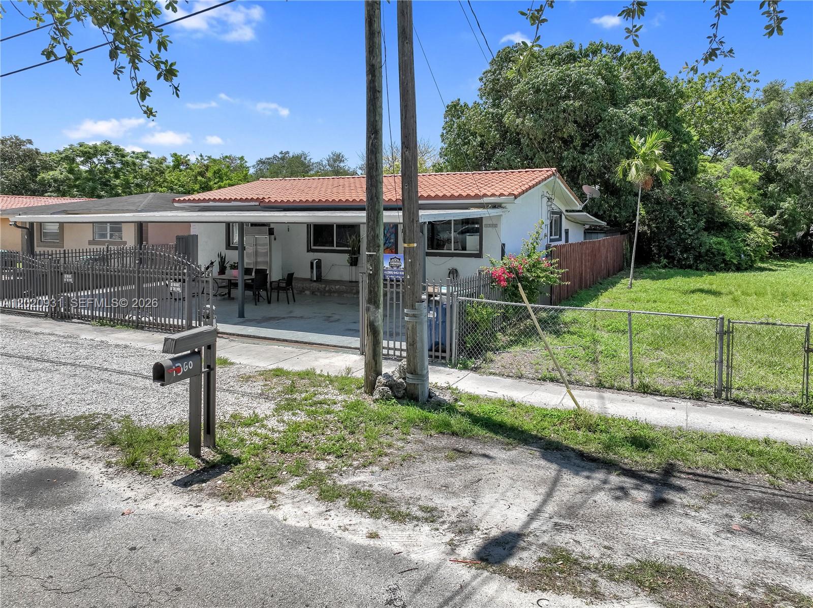 1360 Northwest 77th Street Miami, FL 33147 - Photo 30 of 41 a front view of house with a yard and green space