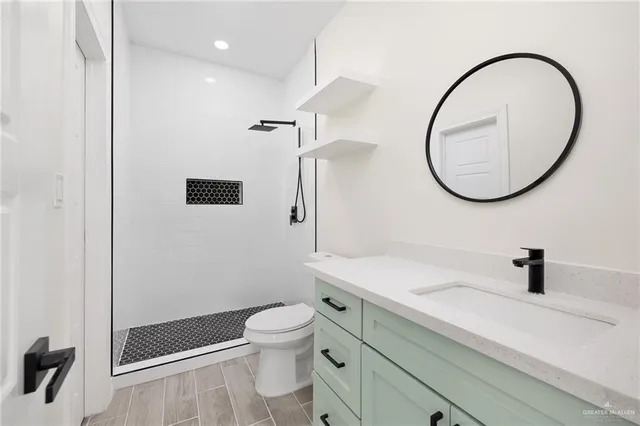 a bathroom with a sink a toilet and a mirror